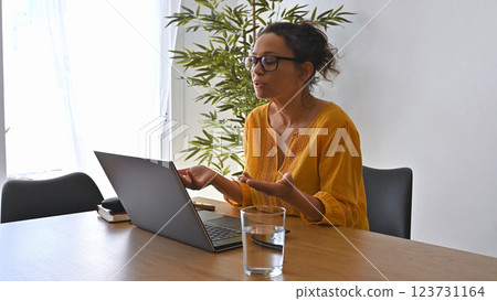 Woman Entrepreneur Working Remotely in a Modern Home Office Space Woman Entrepreneur Working Remotely in a Modern Home Office Space 123731164