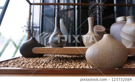 Beige ceramic vases with dry cotton branches. Neutral trendy colors interior decoration . 123732084