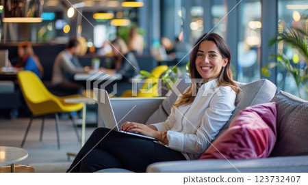 Modern Office Collaboration, Smiling Businesswoman on Video Call in Comfortable Lounge Area Showcasing Flexible Workspace Benefits Modern Office Collaboration, Smiling Businesswoman on Video Call in Comfortable Lounge Area Showcasing Flexible Workspace Benefits 123732407