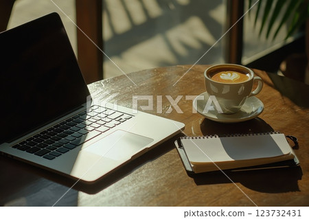 A laptop and a cup of coffee sit on a wooden table A laptop and a cup of coffee sit on a wooden table 123732431