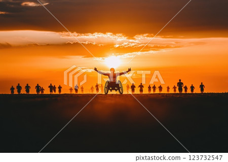Determined Athlete in Racing Wheelchair Crosses Finish Line Against Sunset Background 123732547