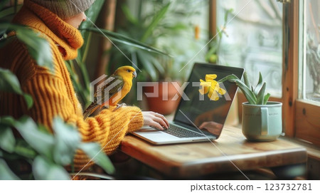 A person working on a laptop in a cozy cafe with a bird perched on the table, Lifestyle of a digital nomad with animal companionship A person working on a laptop in a cozy cafe with a bird perched on the table, Lifestyle of a digital nomad with animal companionship 123732781