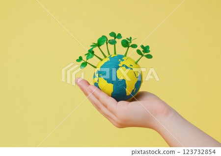 A hand holding a globe with green plants on it. Concept of taking care of the environment and the importance of preserving the earth A hand holding a globe with green plants on it. Concept of taking care of the environment and the importance of preserving the earth 123732854