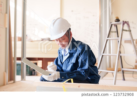 A male craftsman inspecting light steel beams at a construction site 123732908