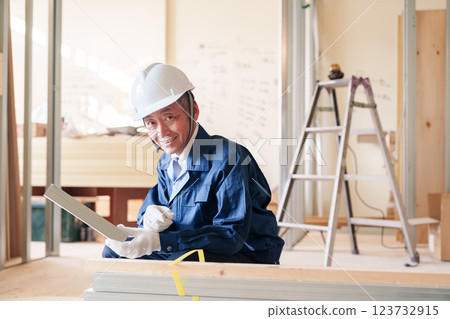 A male craftsman inspecting light steel beams at a construction site A male craftsman inspecting light steel beams at a construction site 123732915