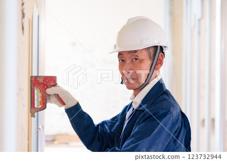 一名男工匠用訂書機固定建築材料 123732944