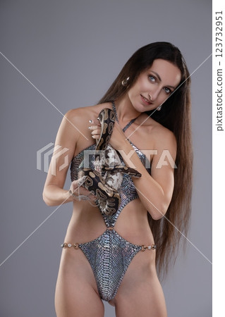 Captivating woman poses with snake, showcasing beauty and elegance in lingerie 123732951