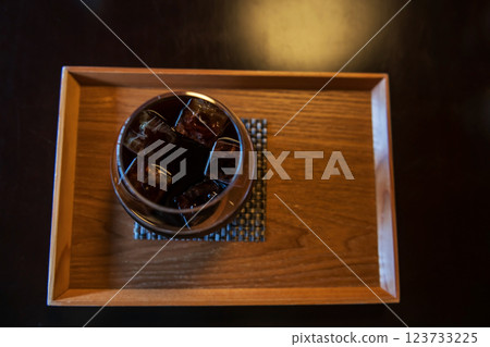 Top view of ice Americano black coffee on wooden cafe table Top view of ice Americano black coffee on wooden cafe table 123733225