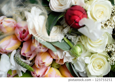 Beautiful holiday card. Mother Day greeting card. Delicate bouquet of white ranunculus and pastel tulips with soft green leaves, creating a romantic and elegant floral scene 123733251
