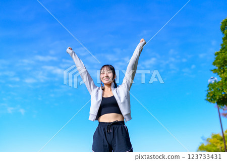 A cool woman pumping her fist into the blue sky while walking Workout Walking Aerobic exercise A cool woman pumping her fist into the blue sky while walking Workout Walking Aerobic exercise 123733431