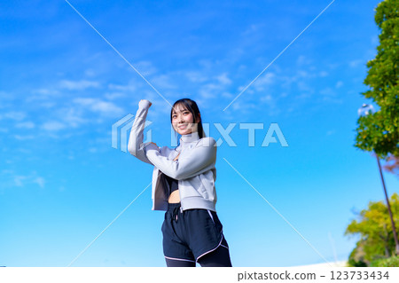 A cool woman pumping her fist into the blue sky while walking Workout Walking Aerobic exercise 123733434