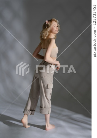 Young woman posing gracefully in casual outfit with soft lighting effects Young woman posing gracefully in casual outfit with soft lighting effects 123733453