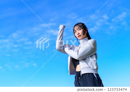 一個很酷的女人一邊走路一邊向藍天揮舞拳頭 鍛煉 修剪 一個很酷的女人一邊走路一邊向藍天揮舞拳頭 鍛煉 修剪 123733474