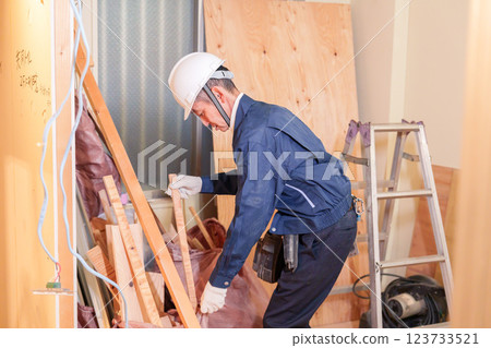 Male carpenter working at an apartment renovation site 123733521