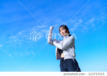 A cool woman pumping her fist into the blue sky while walking Workout Walking Aerobic exercise A cool woman pumping her fist into the blue sky while walking Workout Walking Aerobic exercise 123733525