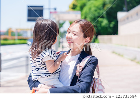 A working mother taking her child to nursery school before work A working mother taking her child to nursery school before work 123733584
