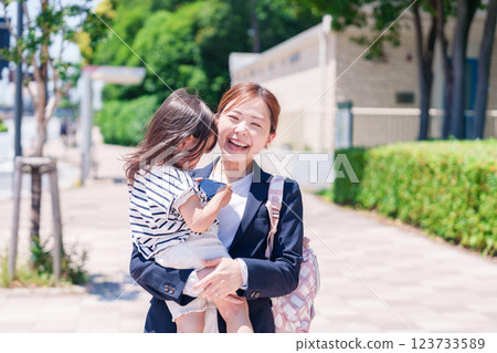 A working mother taking her child to nursery school before work A working mother taking her child to nursery school before work 123733589