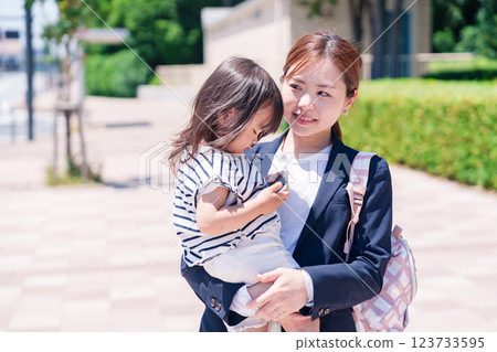 A working mother taking her child to nursery school before work A working mother taking her child to nursery school before work 123733595