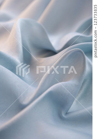Light blue silk fabric forming soft, elegant waves 123733835