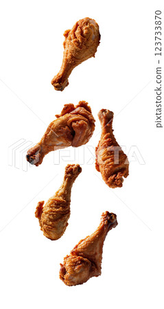 Five crispy fried chicken drumsticks falling against transparent background Five crispy fried chicken drumsticks falling against transparent background 123733870