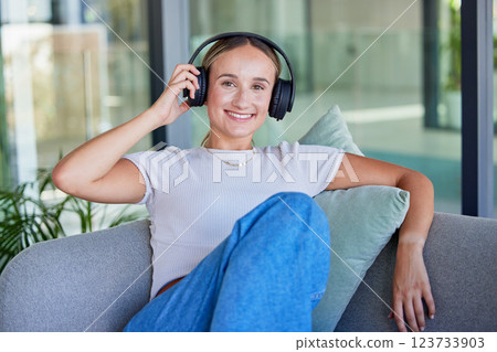 Relax, music and woman listening to radio or podcast on a sofa, cheerful and smile in a living room. Freedom, portrait and streaming by happy, content female enjoying peace and online media audio 123733903