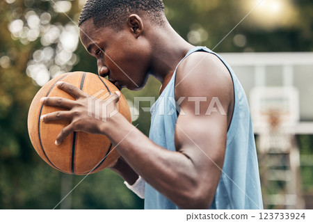 Sports, fitness and man with a kiss to a basketball in training, workout and athletic exercise outdoors. Culture, wellness and young player or athlete with passion and love for playing on court 123733924