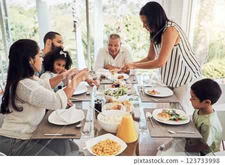 Lunch, eating food and big family in their Mexico home dining room table for summer reunion or quality time together. Puerto Rico mother, grandparents and children with chicken, salad and bread meal 123733998