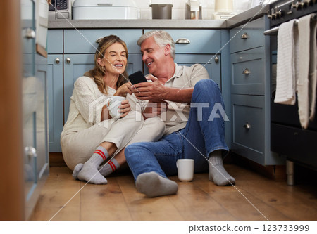 Senior couple, phone or bonding with morning coffee on house or home hotel kitchen floor in trust, love or security. Smile, happy or technology for retirement elderly man and woman with internet news 123733999