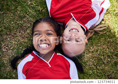 Soccer, sports and children with girl friends lying on a grass field during a football game or match. Kids, training and health with a female child and friend on a pitch for team sport from above 123734011