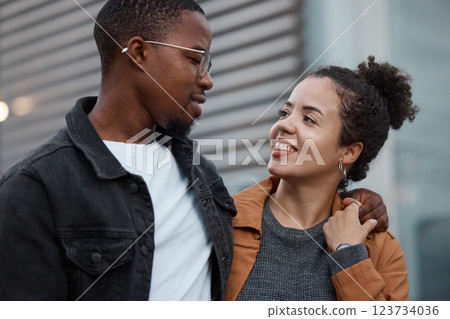 Couple, love and diversity with a man and woman outdoor walking together in an urban city during the day. Dating, relationship and romance with a young male and female outside in town with a smile 123734036