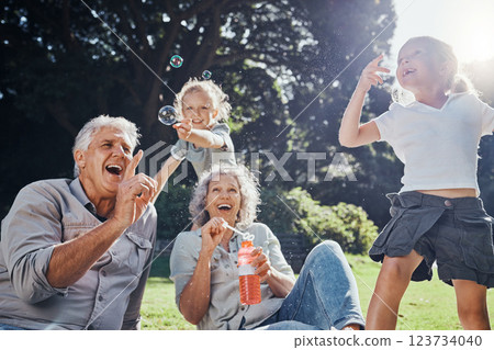 Grandparents, bubbles and children play in park happy together for fun, joy and outdoor happiness. Retired, smile and excited elderly senior couple, girl grandkids and love playing outside in nature Grandparents, bubbles and children play in park happy together for fun, joy and outdoor happiness. Retired, smile and excited elderly senior couple, girl grandkids and love playing outside in nature 123734040