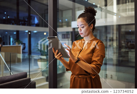 Tablet, working at night and woman employee planning or typing digital strategy in an office. Business, tech and online employee using technology to do internet and web research for a startup project 123734052