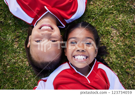 Children soccer player, rest on grass and smile after sport training game with friends in football competition. Happy kids, girl athlete fitness exercise on sports field and relax after outdoor match 123734059