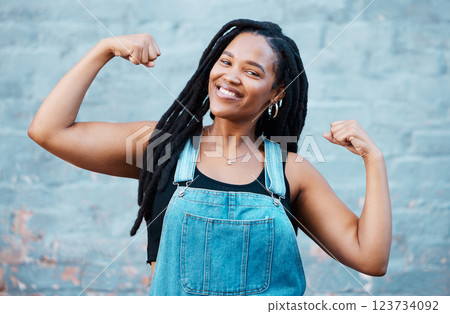 Happy black woman, portrait smile and muscle power, strength and confident pose on wall background. Proud African female flexing biceps, muscles and smiling for women empowerment in South Africa 123734092