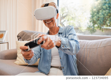 An elderly woman, virtual reality gaming and in retirement playing 3d online game in the living room of house. Senior grandmother in metaverse, vr technology and racing esports on sofa from her home An elderly woman, virtual reality gaming and in retirement playing 3d online game in the living room of house. Senior grandmother in metaverse, vr technology and racing esports on sofa from her home 123734095