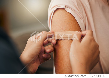 Covid, vaccine and plaster with a doctor and patient consulting in an appointment or checkup at home. Nurse, healthcare and trust with a health professional using a bandaid on an arm after medication Covid, vaccine and plaster with a doctor and patient consulting in an appointment or checkup at home. Nurse, healthcare and trust with a health professional using a bandaid on an arm after medication 123734169