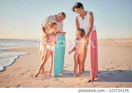 Family, beach and surf with children and parents on the sand by the ocean or sea for surfing, fun and holiday. Water, love and summer with a man, woman and kids on summer vacation at the coast 123734176