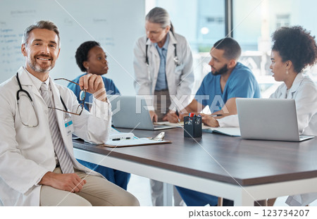 Portrait of doctor with team in a meeting in the office, having a strategy discussion. Business meeting, teamwork and leadership in healthcare, working online using computers in the medical industry 123734207