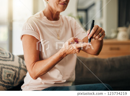 Diabetes, health and elderly woman doing a blood sugar test on her finger with a glucometer. Sickness, healthcare and diabetic senior lady checking her glucose level sitting on a sofa at home. Diabetes, health and elderly woman doing a blood sugar test on her finger with a glucometer. Sickness, healthcare and diabetic senior lady checking her glucose level sitting on a sofa at home. 123734219