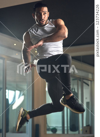 Workout, jumping and health with man in gym for exercise, muscle and cardio. Fitness class, energy and sports center with male person training in studio for wellness, athlete and power challenge 123734226