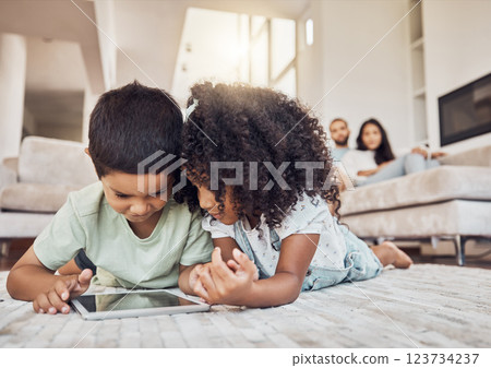 Children, brother and sister on tablet watching, learning or streaming educational videos, games or cartoon on lounge carpet at home. Kids playing on internet for fun and entertainment in brazil Children, brother and sister on tablet watching, learning or streaming educational videos, games or cartoon on lounge carpet at home. Kids playing on internet for fun and entertainment in brazil 123734237