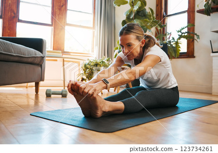 Senior woman, stretching and exercise in living room for fitness, cardio and wellness on yoga mat home training. Retirement, workout and healthy elderly retired person exercising legs on house floor Senior woman, stretching and exercise in living room for fitness, cardio and wellness on yoga mat home training. Retirement, workout and healthy elderly retired person exercising legs on house floor 123734261
