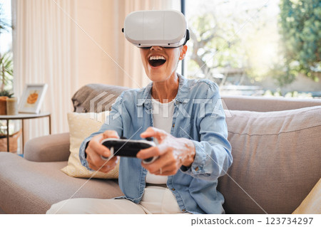VR, metaverse and 3d gaming with a woman playing a video game on a sofa in the living room of her home. Virtual reality, esports and technology with a female gamer enjoying an online experience VR, metaverse and 3d gaming with a woman playing a video game on a sofa in the living room of her home. Virtual reality, esports and technology with a female gamer enjoying an online experience 123734297
