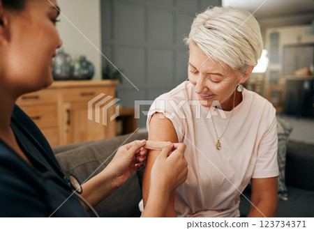 Covid vaccine, plaster and doctor with patient in a health consultation at a retirement house. Nurse, healthcare worker and elderly woman with a bandaid on her arm after a treatment in a nursing home 123734371