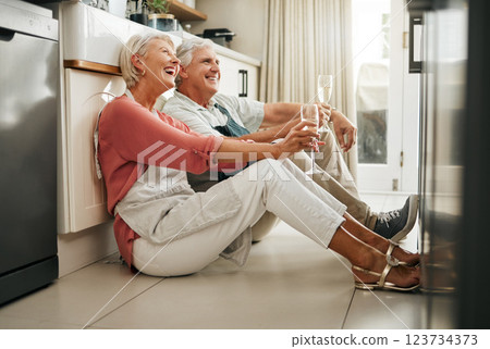 Senior couple, wine and laughing on kitchen floor thinking happy memories and talking about love during a celebration of anniversary, new home or retirement. Old man and woman telling a funny joke Senior couple, wine and laughing on kitchen floor thinking happy memories and talking about love during a celebration of anniversary, new home or retirement. Old man and woman telling a funny joke 123734373