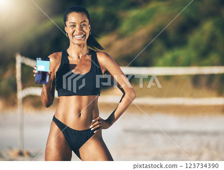 Beach, technology and fitness app, woman with phone in the sand and summer sun. Exercise, bikini and sports workout on holiday in Brazil, happy and girl at volleyball net with mobile application. Beach, technology and fitness app, woman with phone in the sand and summer sun. Exercise, bikini and sports workout on holiday in Brazil, happy and girl at volleyball net with mobile application. 123734390