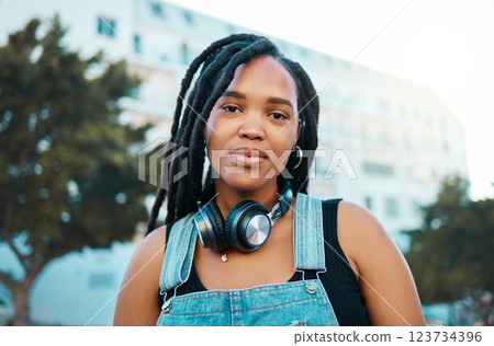 City, urban and headphones black woman portrait in urban gen z fashion, outdoor travel or youth lifestyle. Young, trendy african girl or student face with technology for 5g audio streaming in summer 123734396