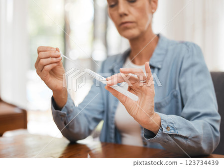 Woman, hands and covid for PCR, test or results on table for healthcare diagnosis at home by desk. Sick female testing for corona virus, disease or illness holding kit for self screening in pandemic 123734439