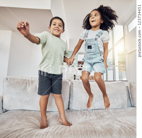Children, brother and sister bonding and jumping on sofa in house, home or hotel living room in fun, play and energy game. Smile, happy or adhd kids or hyperactive Mexico boy and girl with sugar rush 123734451