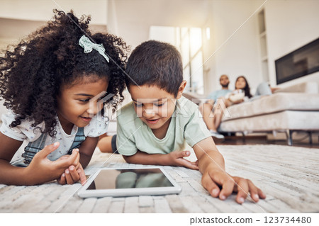 Streaming video, internet tablet and children watching cartoon on technology on the living room floor. Sibling kids learning on the internet with tech and relax with movie online together in house 123734480